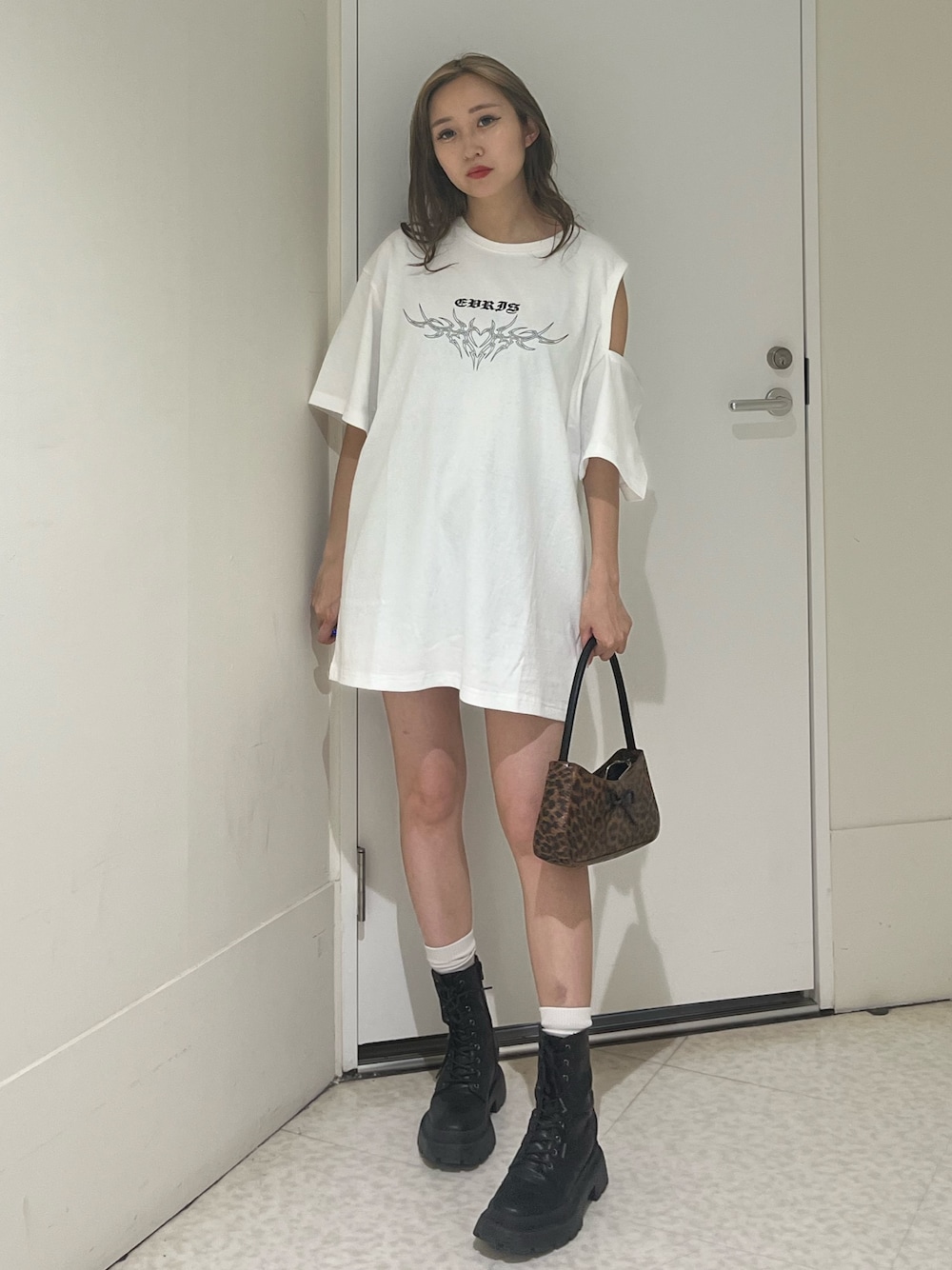 ブラック系のブーツ、ブラウン系のハンドバッグ、ホワイト系のTシャツ/カットソーを着用したレディースの夏コーディネートの1枚目の写真