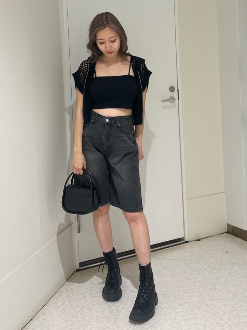 ブラック系のブーツ、ブラック系のハンドバッグ、ブラック系のキャミソールを着用したレディースの夏コーディネートの1枚目の写真