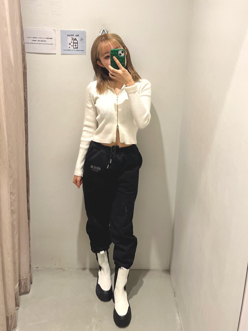 ブラック系のスウェットパンツ、ホワイト系のブーツ、ホワイト系のニット/セーターを着用したレディースの冬コーディネートの1枚目の写真