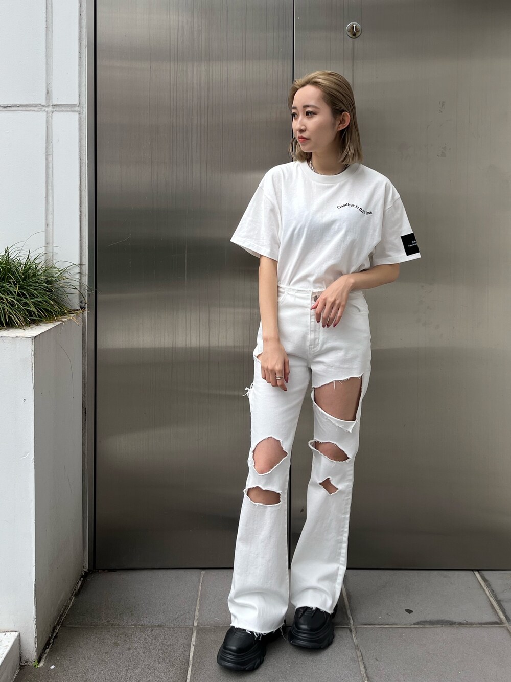 ホワイト系のデニムパンツ、ホワイト系のTシャツ/カットソー、ブラック系のスニーカーを着用したレディースの春コーディネートの1枚目の写真