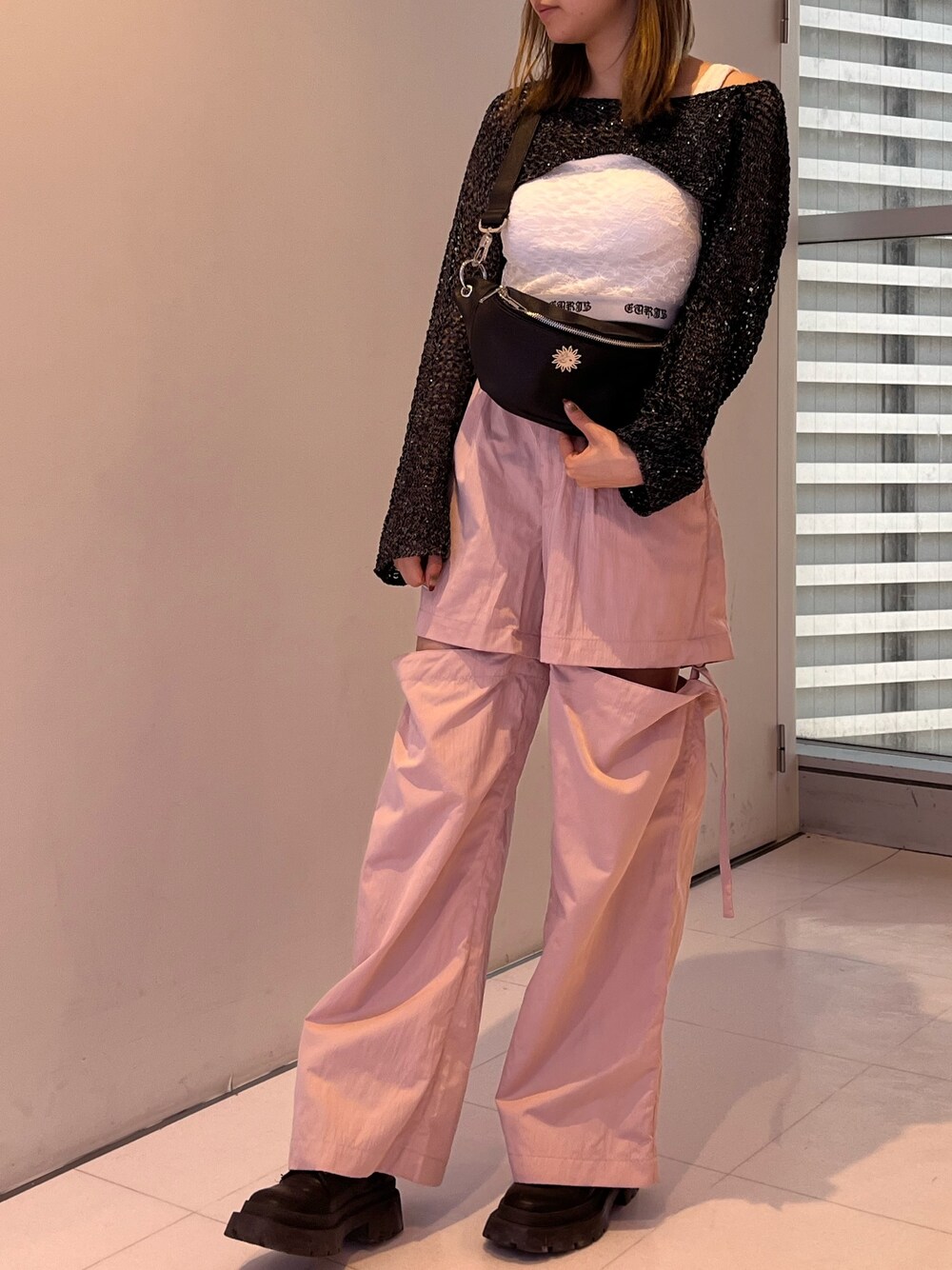 ピンク系のカーゴパンツ、ブラック系のキャミソール、ブラック系のニット/セーターを着用したレディースの春コーディネートの1枚目の写真