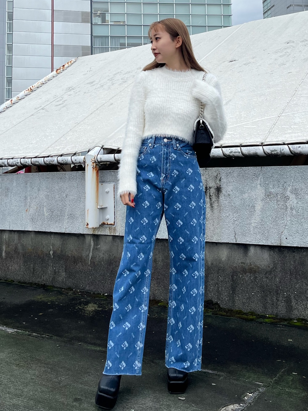 ホワイト系のニット/セーター、ブルー系のデニムパンツ、ブラック系のブーツを着用したレディースの秋コーディネートの1枚目の写真