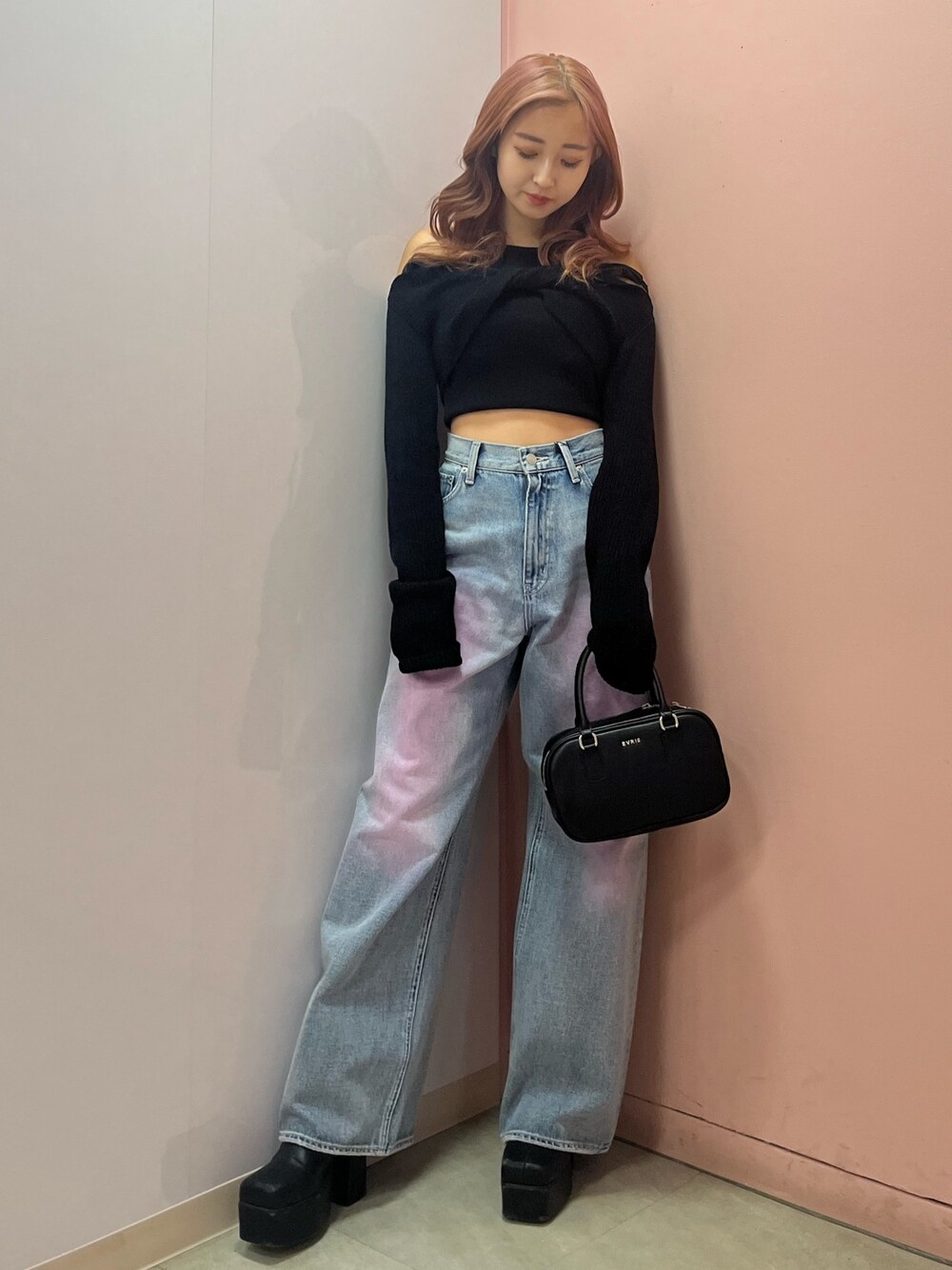 ブラック系のボストンバッグ、ブラック系のブーツ、イエロー系のニット/セーターを着用したレディースの春コーディネートの1枚目の写真