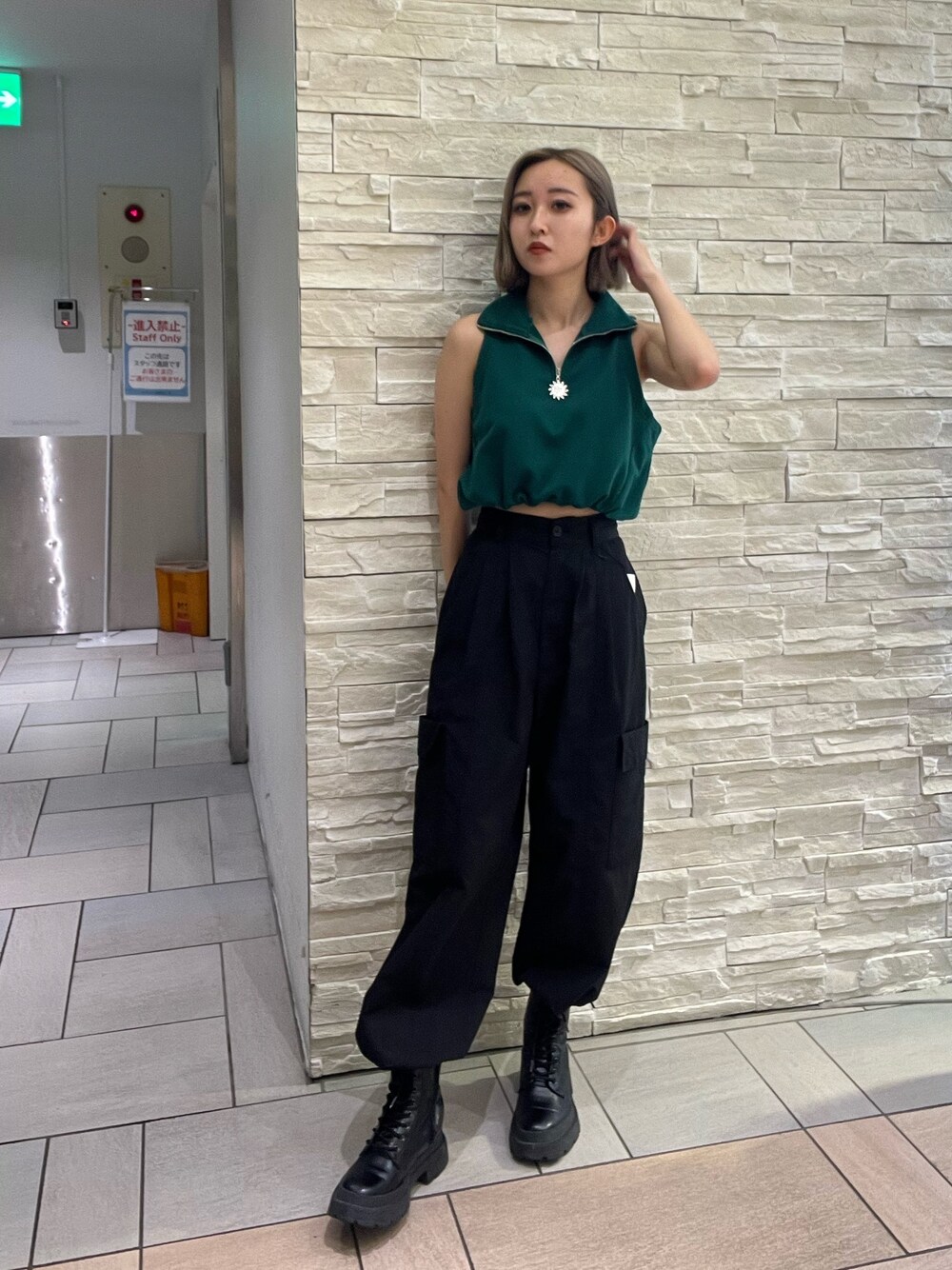 ブラック系のタンクトップ、パープル系のカーゴパンツ、ブラック系のブーツを着用したレディースの春コーディネートの1枚目の写真