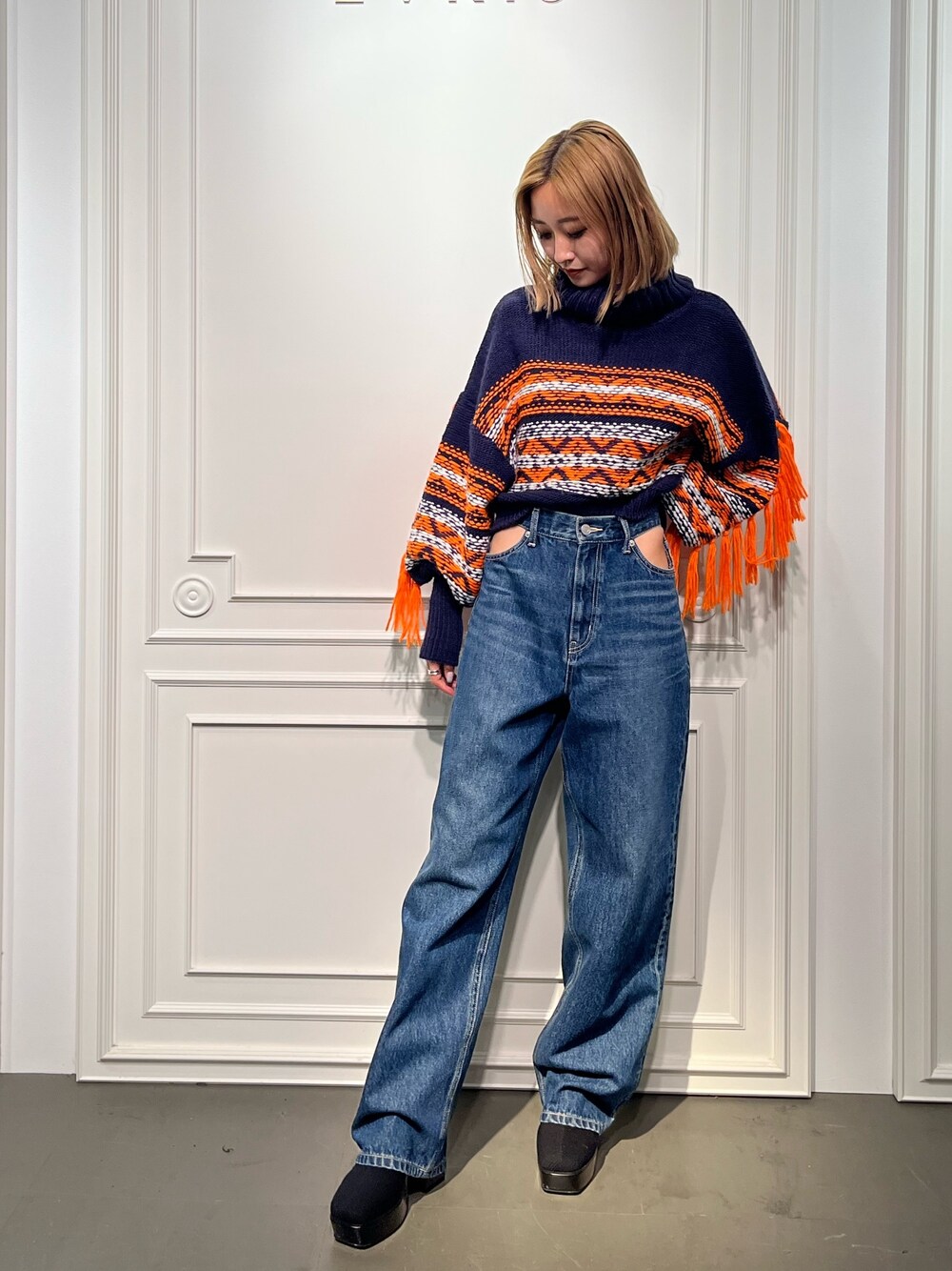 ブルー系のニット/セーター、ブラック系のブーツ、ブラック系のデニムパンツを着用したレディースの秋コーディネートの1枚目の写真