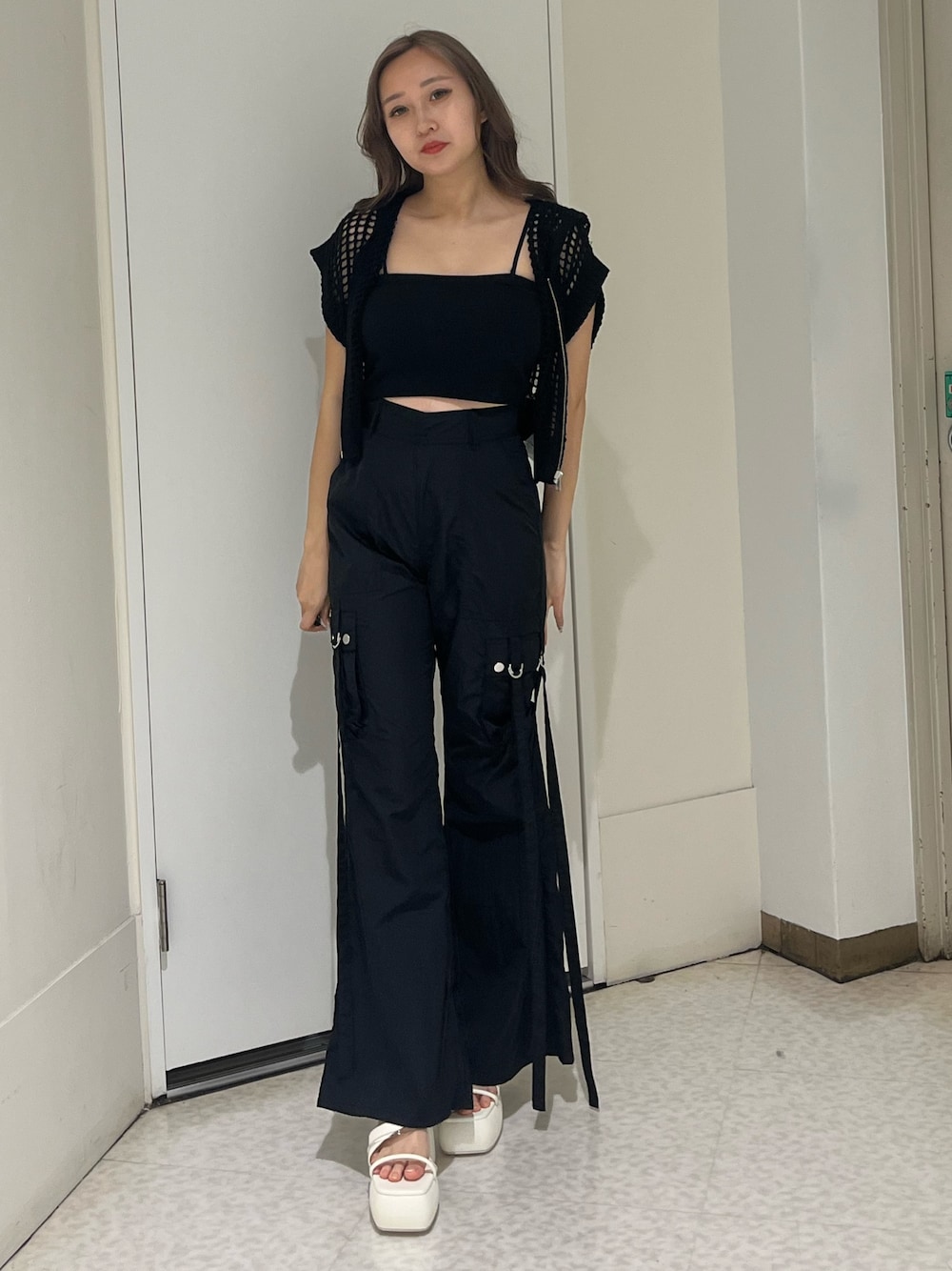 ブラック系のニット/セーター、ブラック系のキャミソール、ブラック系のカーゴパンツを着用したレディースの夏コーディネートの1枚目の写真