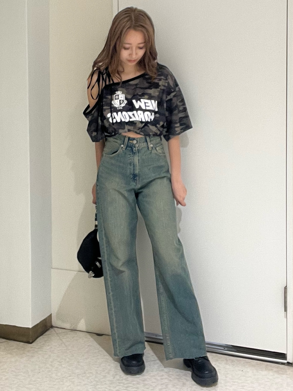 ブルー系のデニムパンツ、その他のTシャツ/カットソー、ブラック系のブーツを着用したレディースの春コーディネートの1枚目の写真