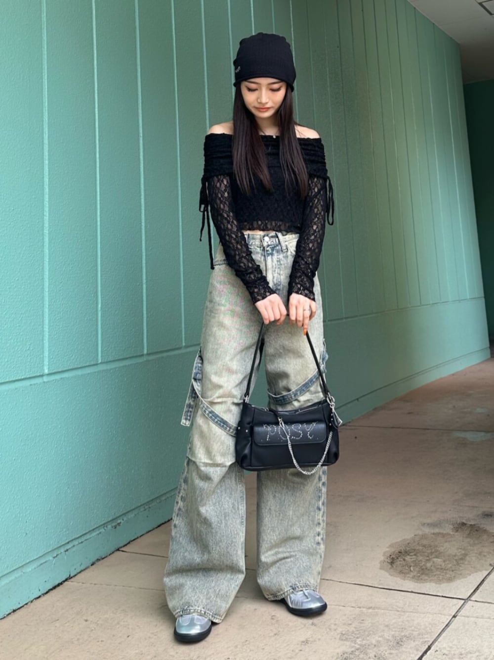 ブルー系のデニムパンツ、ブラック系のハンドバッグ、ブラック系のTシャツ/カットソーを着用したレディースの春コーディネートの1枚目の写真