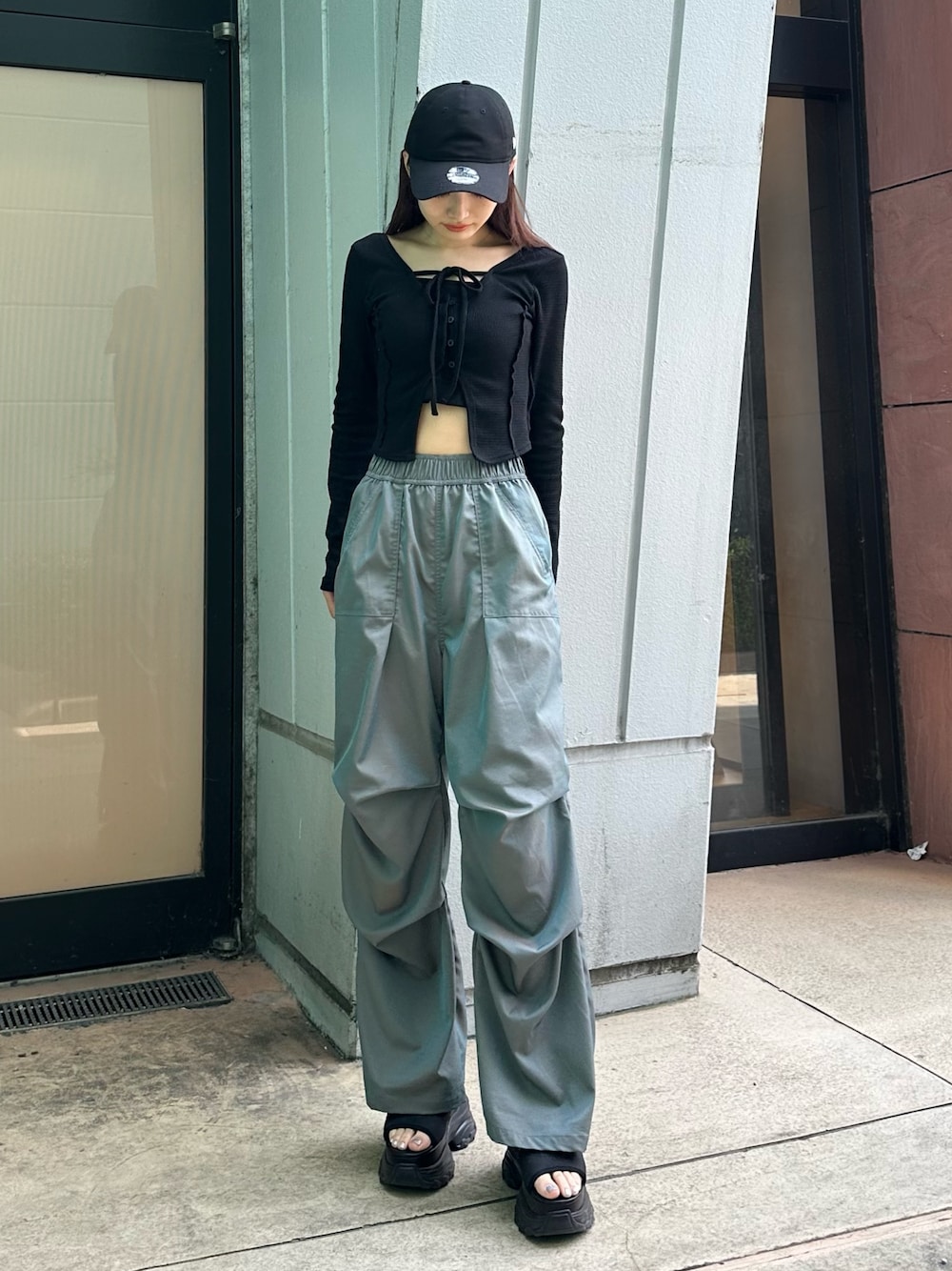 グリーン系のその他パンツ、ブラック系のTシャツ/カットソー、ブラック系のサンダルを着用したレディースの春コーディネートの1枚目の写真