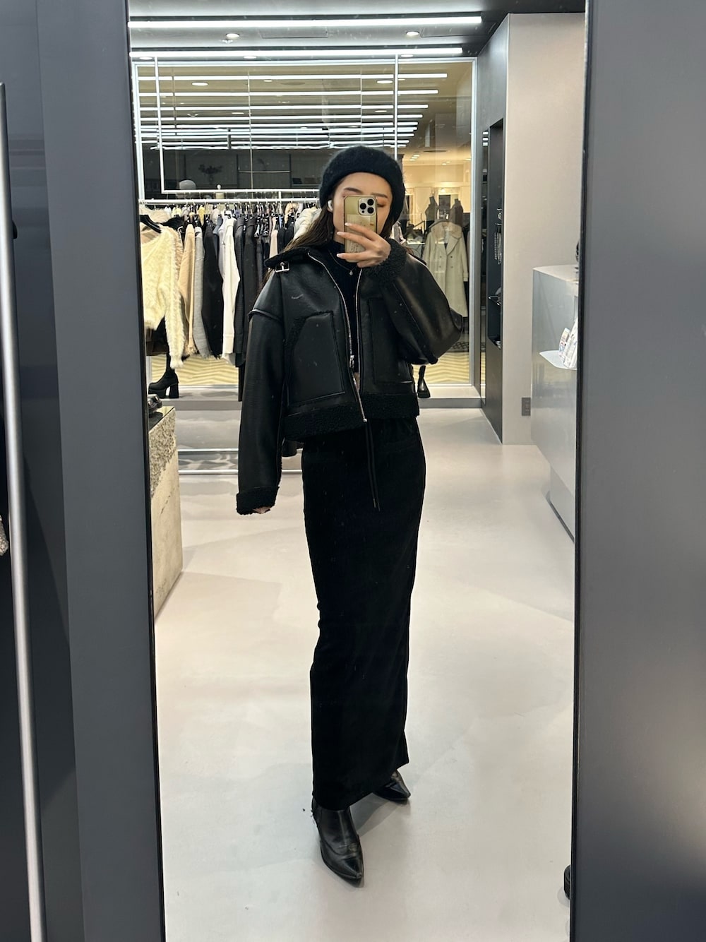 ブラック系のブルゾン、ブラック系のニット/セーター、ブラック系のブーツを着用したレディースの冬コーディネートの1枚目の写真