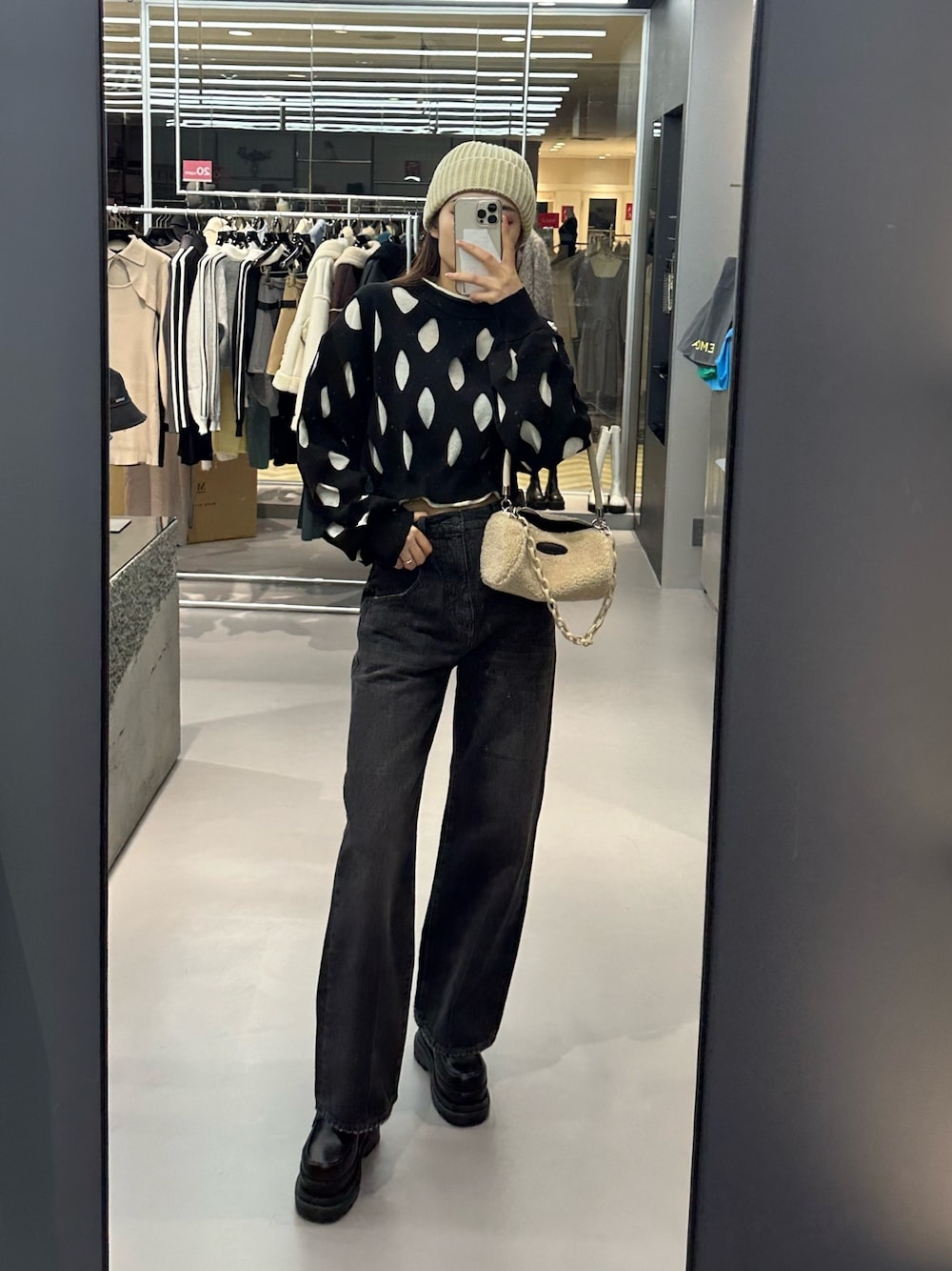 ブラック系のデニムパンツ、ホワイト系のハンドバッグ、ブラック系のローファーを着用したレディースの冬コーディネートの1枚目の写真