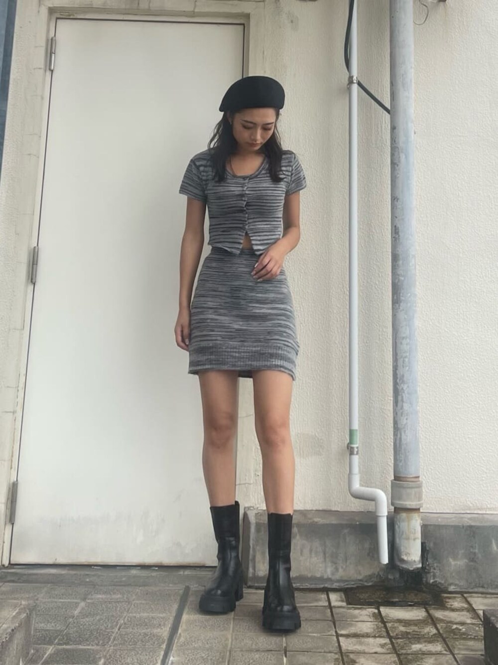 ブラック系のブーツ、ブラック系のスカート、ブラック系のニット/セーターを着用したレディースの夏コーディネートの1枚目の写真