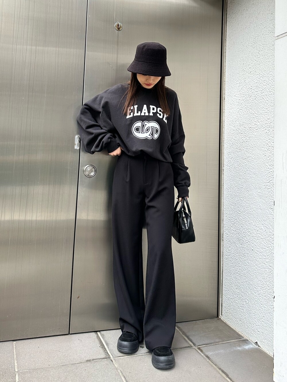 ブラック系のその他パンツ、ブラック系のハンドバッグ、ブラック系のTシャツ/カットソーを着用したレディースの冬コーディネートの1枚目の写真