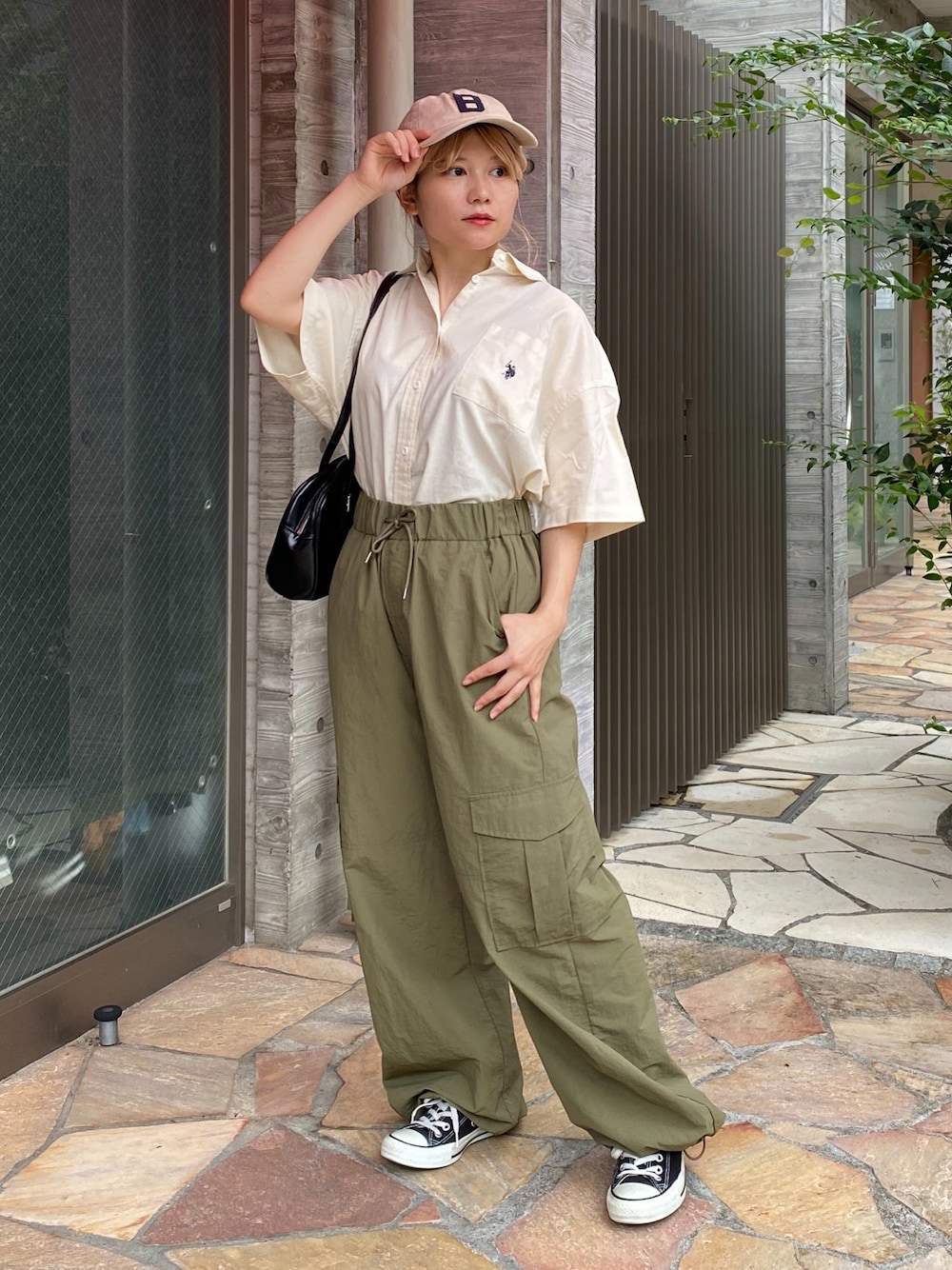 ホワイト系のシャツ/ブラウス、グリーン系のカーゴパンツ、ブラック系のスニーカーを着用したレディースの夏コーディネートの1枚目の写真