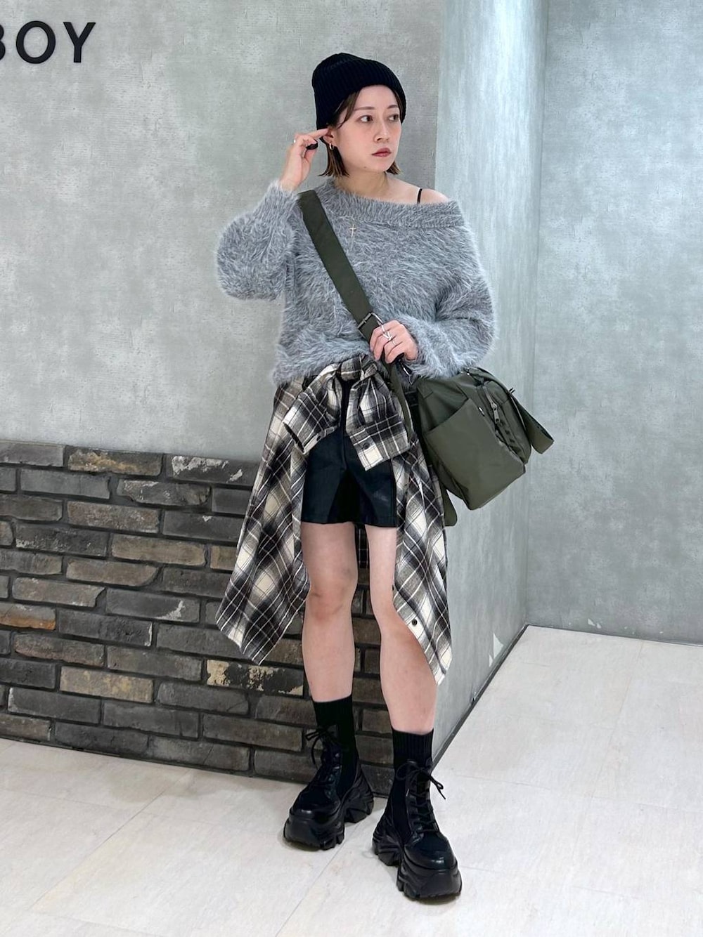 ブラック系のブーツ、グリーン系のボストンバッグ、ブラック系のその他パンツを着用したレディースの秋コーディネートの1枚目の写真