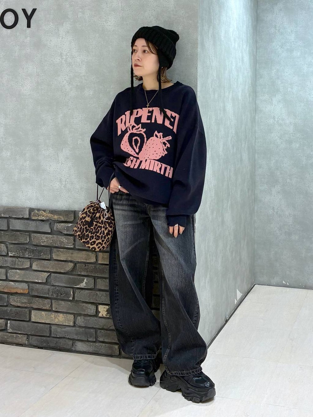 ブラック系のスニーカー、ブルー系のニット/セーター、ブラック系のデニムパンツを着用したレディースの秋コーディネートの1枚目の写真