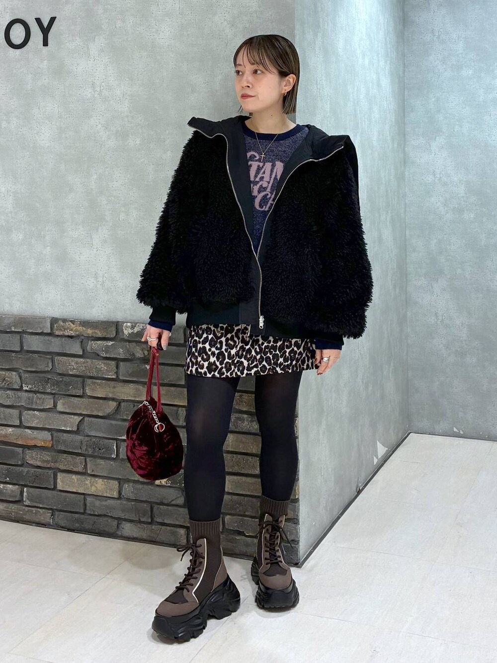 ブラウン系のブーツ、ブラック系のブルゾン、ブラウン系のスカートを着用したレディースの冬コーディネートの1枚目の写真