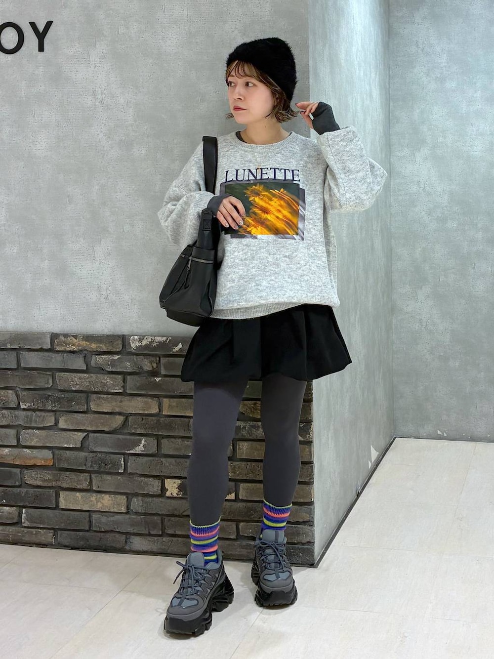 グレー系のスニーカー、ブラック系のボストンバッグ、ブラック系のその他パンツを着用したレディースの冬コーディネートの1枚目の写真