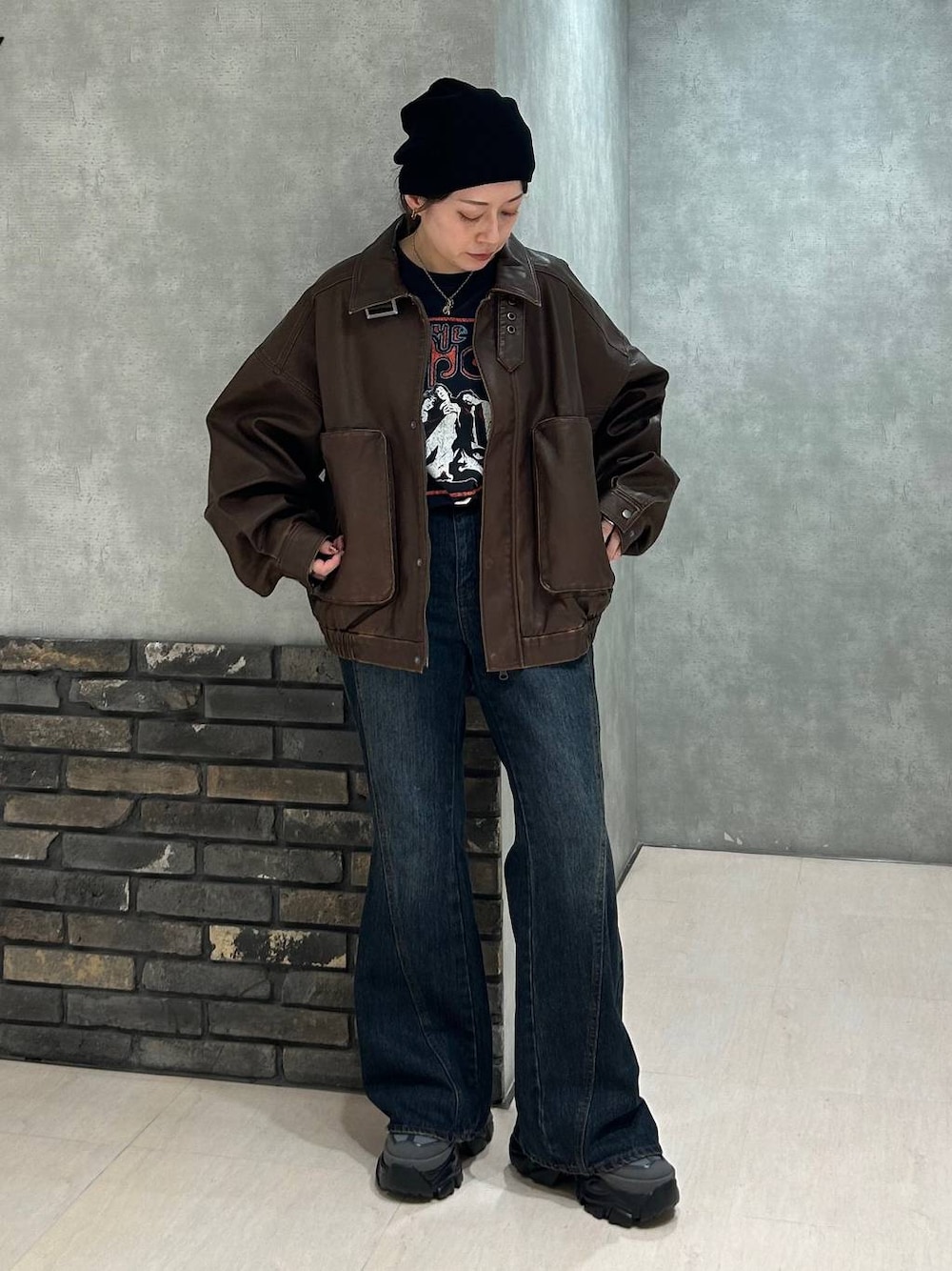 グレー系のスニーカー、ブルー系のデニムパンツ、ブラック系のTシャツ/カットソーを着用したレディースの秋コーディネートの1枚目の写真