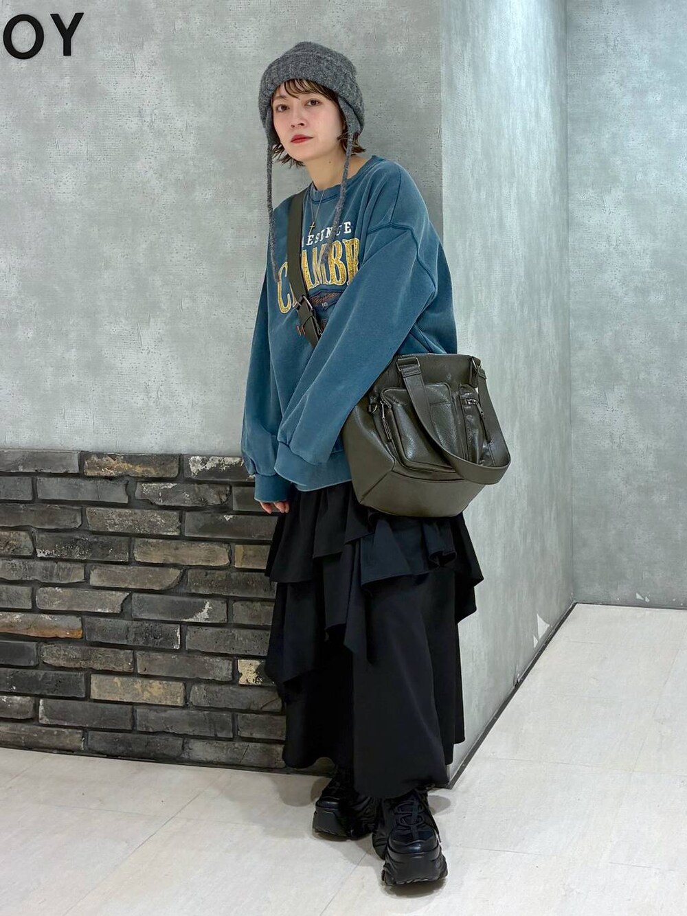 ブラック系のスニーカー、グリーン系のボストンバッグ、グリーン系のスウェットを着用したレディースの冬コーディネートの1枚目の写真