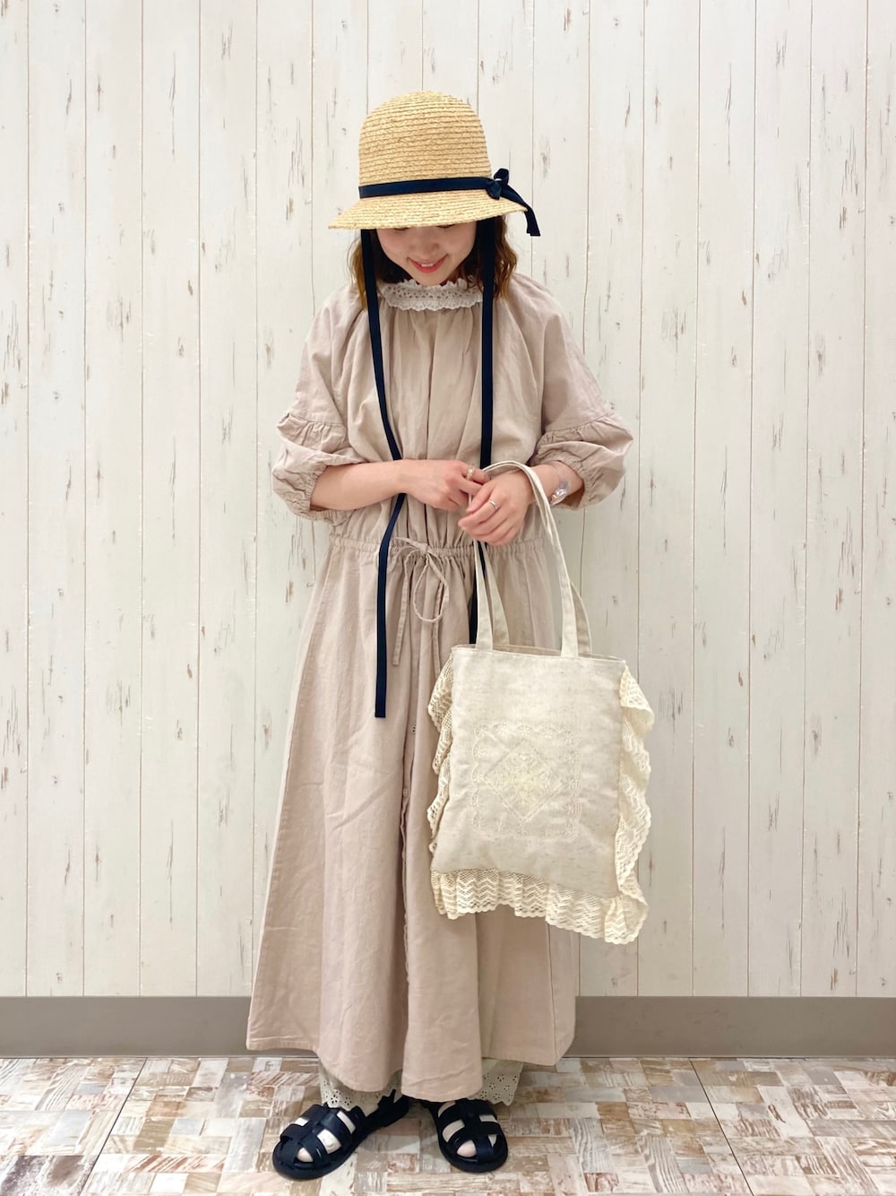 ベージュ系のワンピース、ホワイト系のトートバッグ、ブラック系のサンダルを着用したレディースの春コーディネートの1枚目の写真