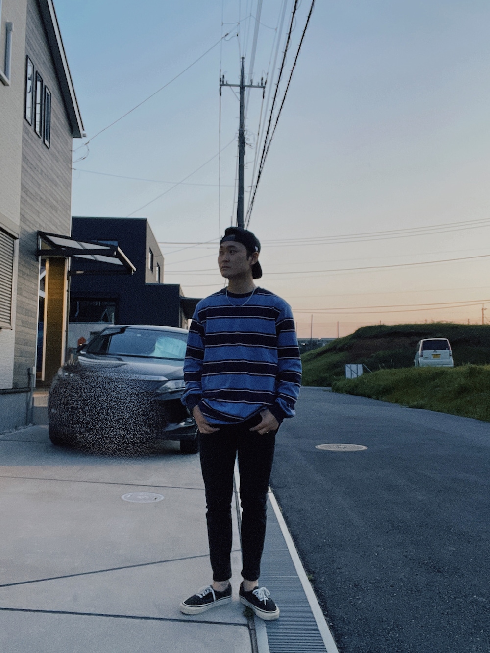 ブルー系のTシャツ/カットソー、ブラック系のデニムパンツ、ブラック系のスニーカーを着用したメンズの春コーディネートの1枚目の写真