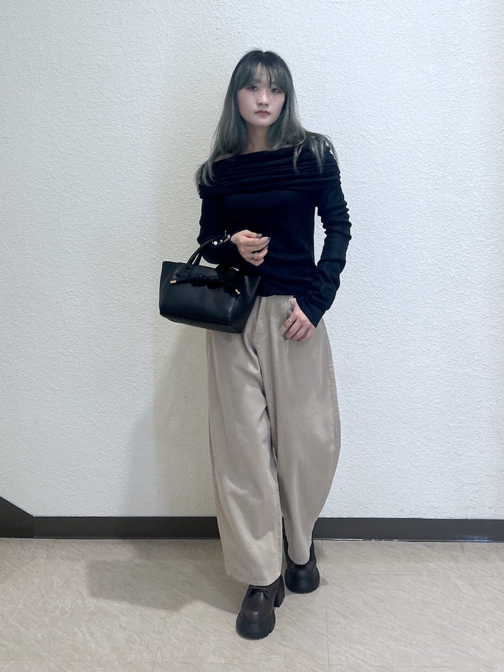 ベージュ系のその他パンツ、ブラック系のトートバッグ、ブルー系のニット/セーターを着用したレディースの秋コーディネートの1枚目の写真