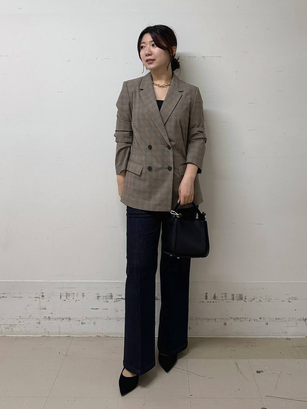 ブラック系のハンドバッグ、ブラック系のキャミソール、ブルー系のデニムパンツを着用したレディースの夏コーディネートの1枚目の写真