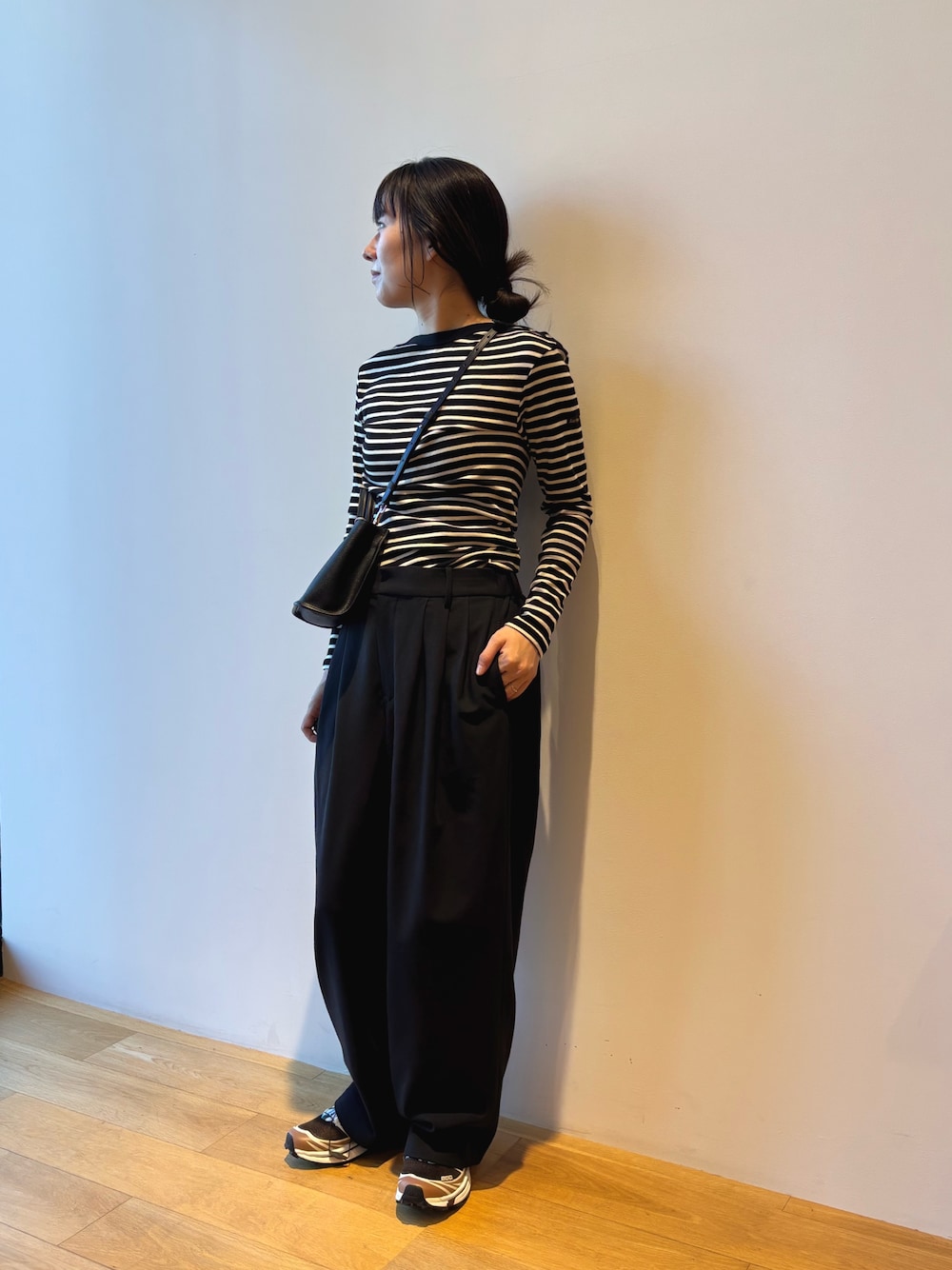 ブラック系のその他パンツ、ブラウン系のスニーカー、ブラック系のハンドバッグを着用したレディースの夏コーディネートの1枚目の写真