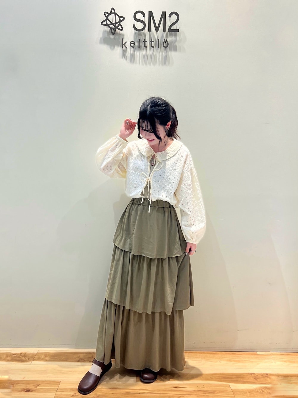 グリーン系のスカート、ホワイト系のシャツ/ブラウス、ブラウン系のドレスシューズを着用したレディースの夏コーディネートの1枚目の写真