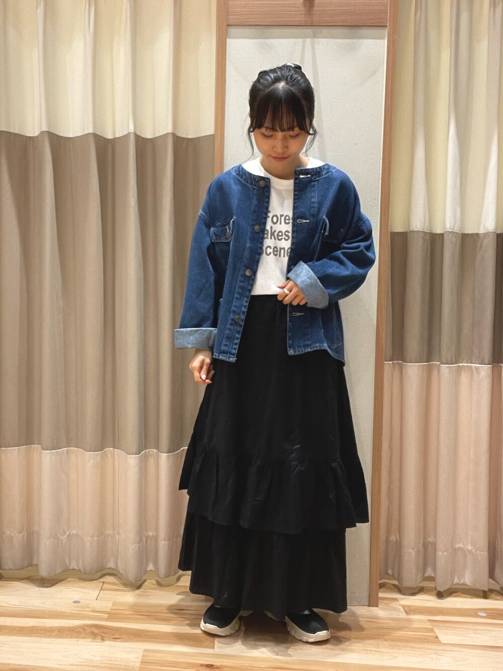 ブルー系のノーカラージャケット、ホワイト系のTシャツ/カットソー、ブラック系のスカートを着用したレディースの秋コーディネートの1枚目の写真