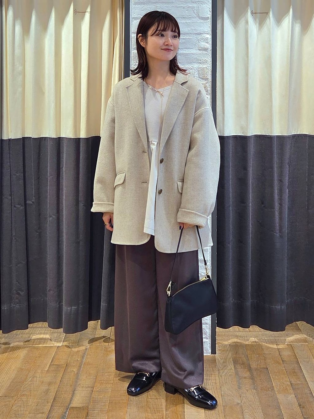 ブラック系のローファー、ブラック系のショルダーバッグ、ベージュ系のテーラードジャケットを着用したレディースの秋コーディネートの1枚目の写真