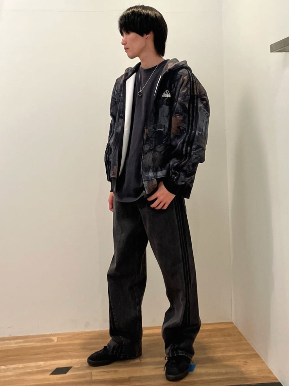 ブラック系のスニーカー、ブラック系のパーカー、ブラック系のデニムパンツを着用したメンズの冬コーディネートの1枚目の写真