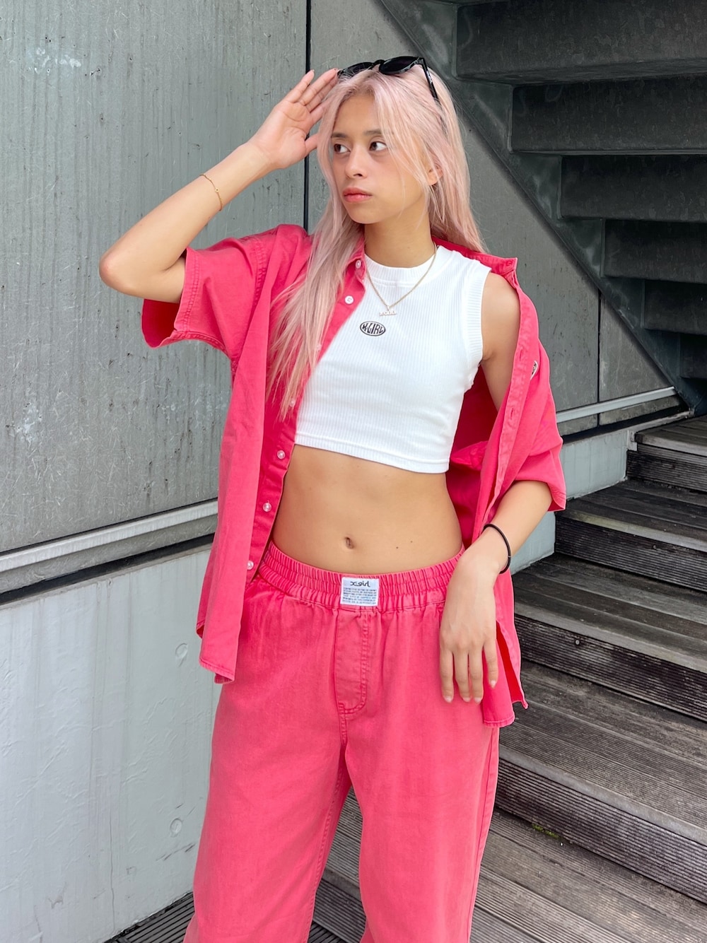 レッド系のシャツ/ブラウス、レッド系のその他パンツ、ホワイト系のタンクトップを着用したレディースの春コーディネートの1枚目の写真