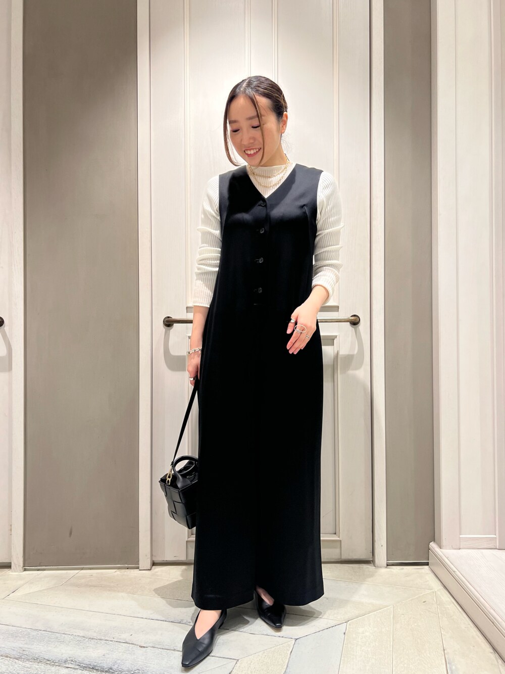 「ニット、オールインワン、モノトーン、サテンパンツ、ハイゲージニット、きれいめカジュアル、ミニバッグ、qualite、秋冬コーデ、骨格ストレート」｜「qualiteのVネックストレートオールインワン（つなぎ/オールインワン、ブラック系）」を使った、平沼 彩花さん（レディース・161cm）の秋コーディネートの1枚目の写真