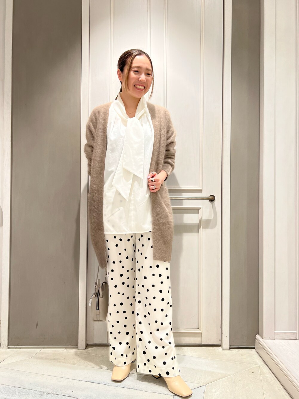 「カーディガン、ブラウン、ドット柄、きれいめカジュアル、フレアパンツ、ミニバッグ、ボウタイブラウス、qualite、秋冬コーデ、骨格ストレート」｜「qualiteのフォックスラクーンニットカーデ（カーディガン/ボレロ、ブラウン系）」を使った、平沼 彩花さん（レディース・161cm）の秋コーディネートの1枚目の写真