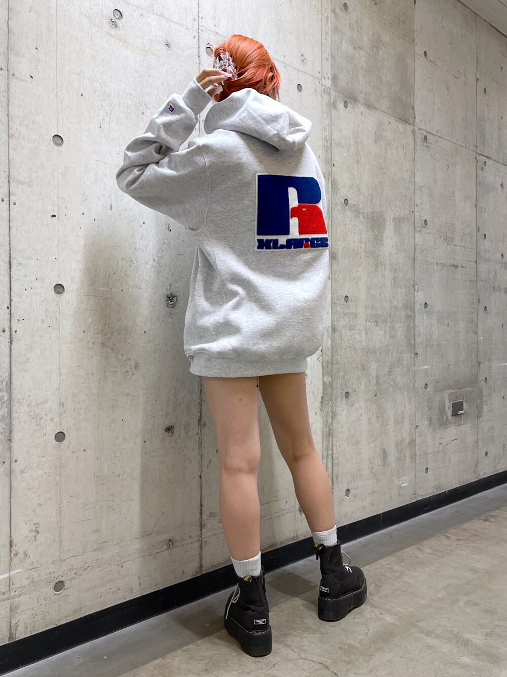 グレー系のパーカー、ブラック系のスニーカーを着用したレディースの秋コーディネートの1枚目の写真