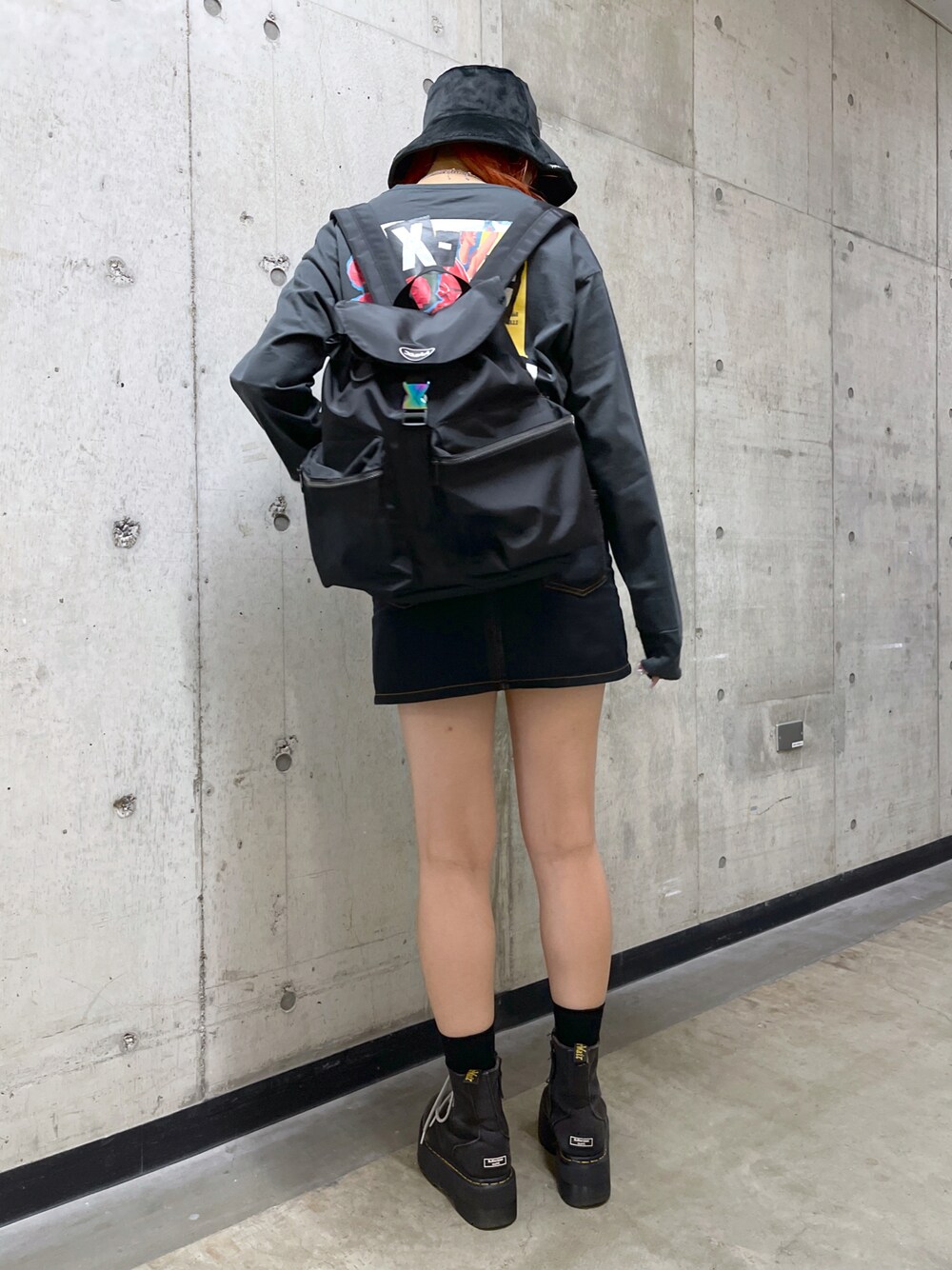 ブラック系のバックパック/リュック、ブラック系のスカート、グレー系のTシャツ/カットソーを着用したレディースの秋コーディネートの1枚目の写真