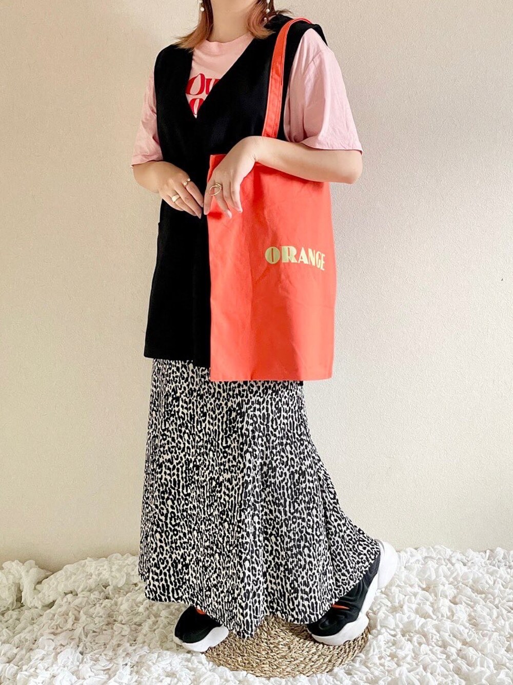 オレンジ系のトートバッグ、その他のスカート、ブラック系のサンダルを着用したレディースの夏コーディネートの1枚目の写真