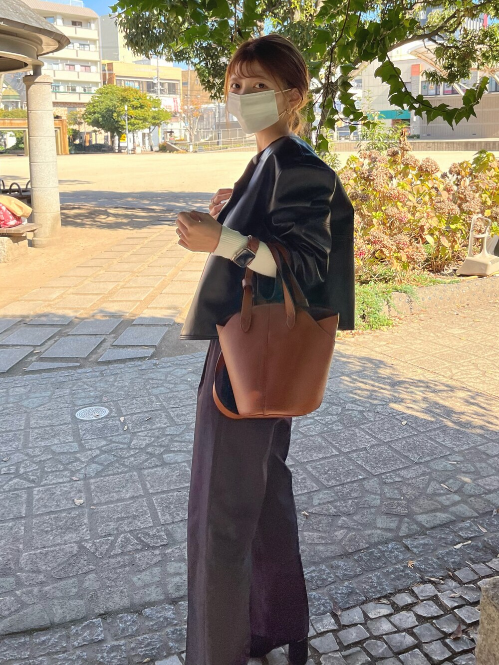 ブラウン系のバッグ、ブラック系のジャケット/アウター、ブラウン系の腕時計を着用したレディースの冬コーディネートの1枚目の写真