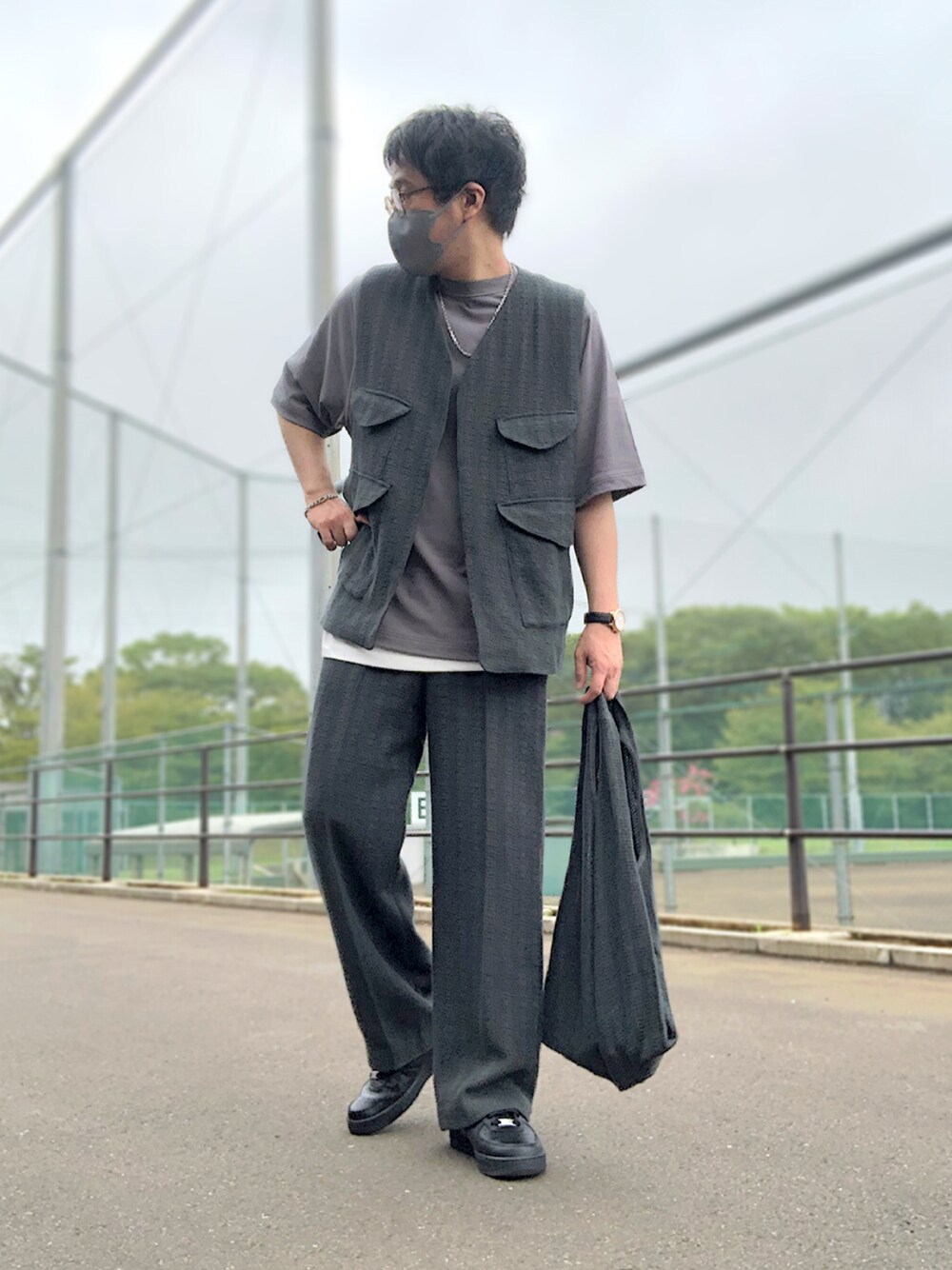 グレー系のベスト、グレー系のTシャツ/カットソー、ホワイト系のタンクトップを着用したメンズの秋コーディネートの1枚目の写真