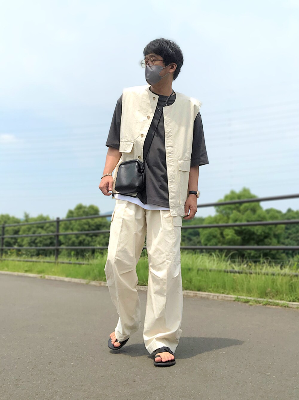 ベージュ系のセットアップ、グレー系のTシャツ/カットソー、ブラック系のショルダーバッグを着用したメンズの夏コーディネートの1枚目の写真