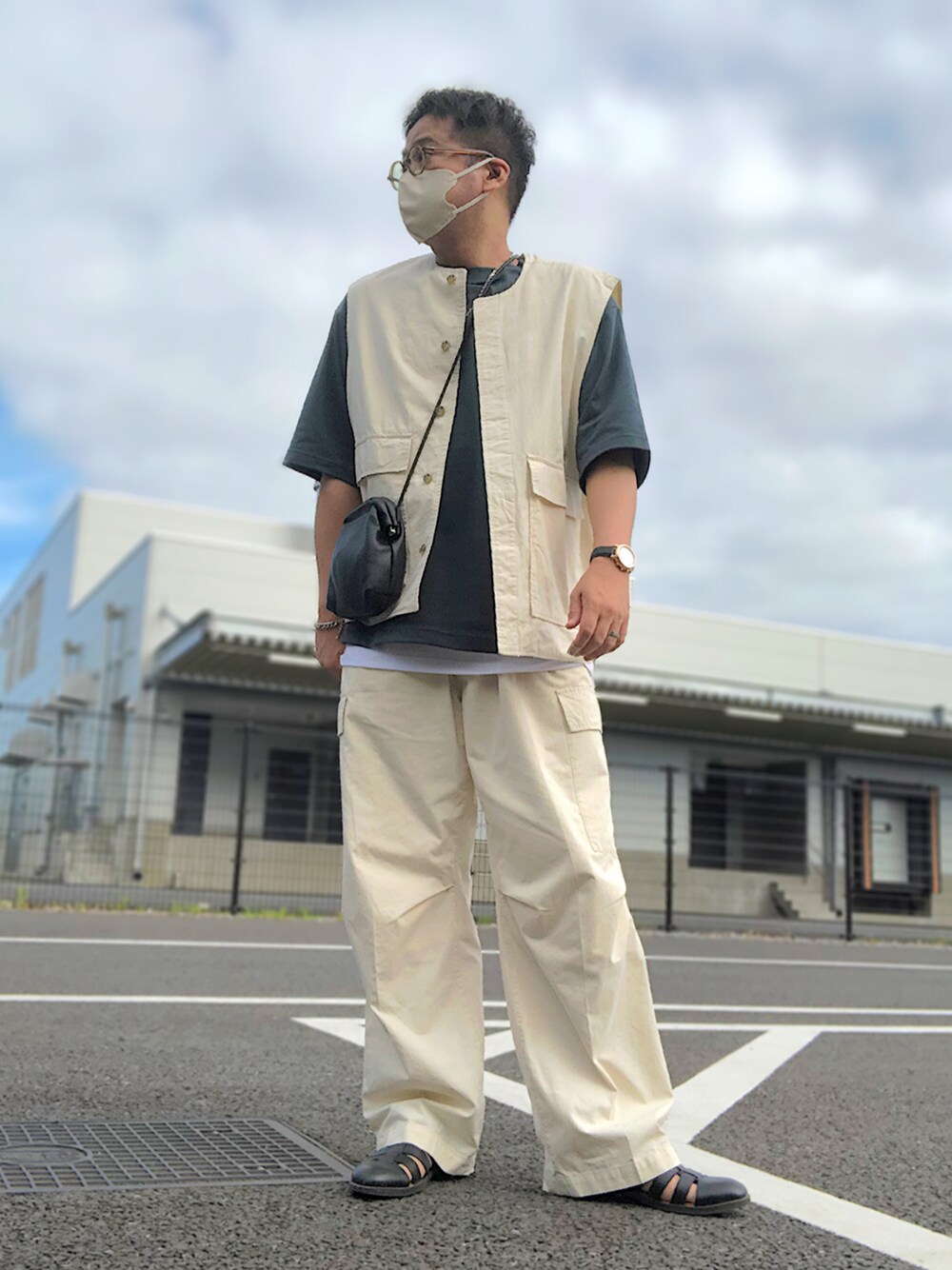 ベージュ系のセットアップ、グリーン系のTシャツ/カットソー、ブラック系のショルダーバッグを着用したメンズの夏コーディネートの1枚目の写真