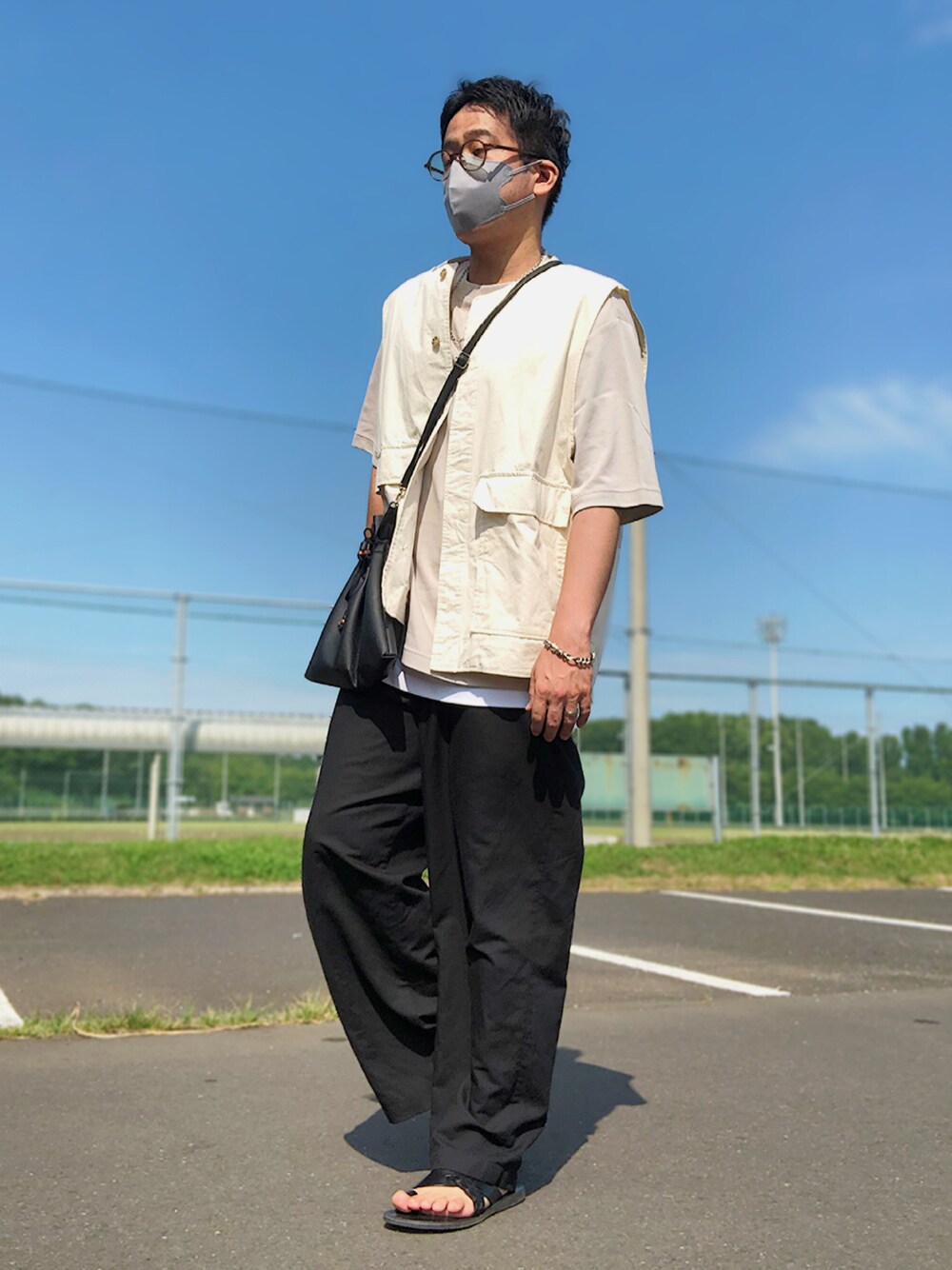 ベージュ系のセットアップ、ブラック系のショルダーバッグ、グレー系のTシャツ/カットソーを着用したメンズの夏コーディネートの1枚目の写真