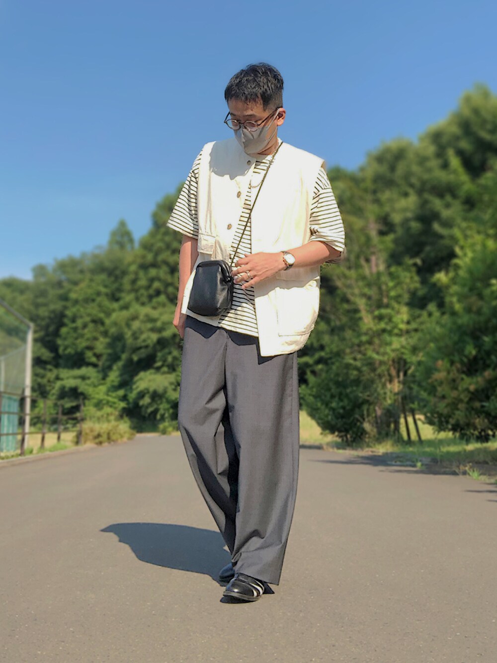 ベージュ系のセットアップ、ホワイト系のTシャツ/カットソー、ブラック系のショルダーバッグを着用したメンズの夏コーディネートの1枚目の写真
