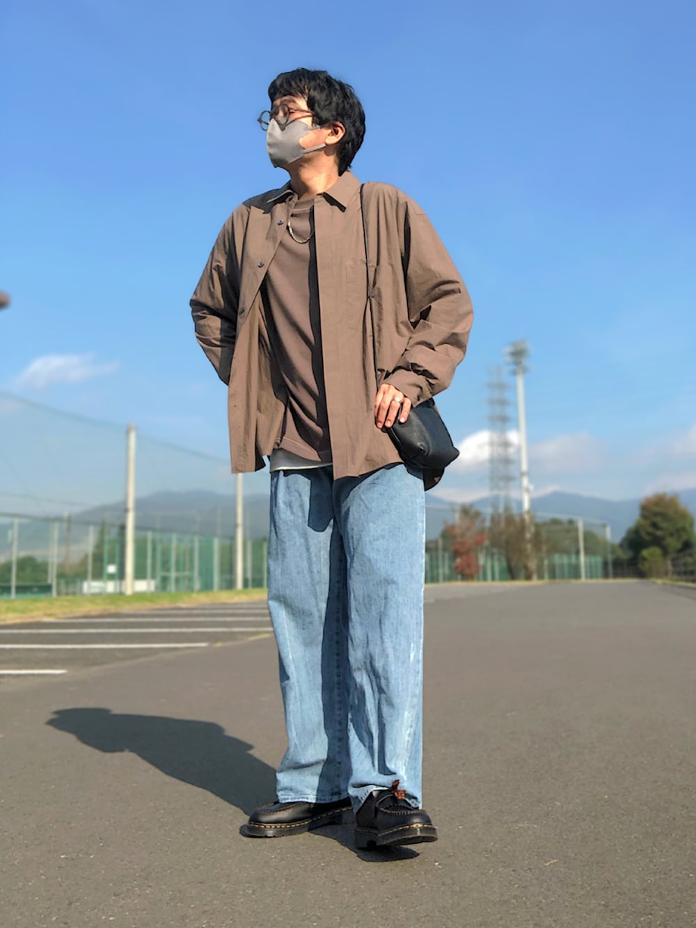 ブラウン系のTシャツ/カットソー、ブラック系のショルダーバッグ、グレー系のタンクトップを着用したメンズの秋コーディネートの1枚目の写真