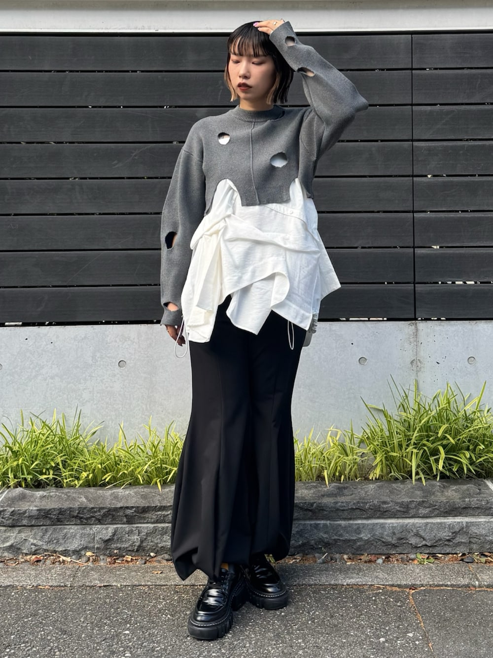 グレー系のニット/セーター、ホワイト系のシャツ/ブラウス、グレー系のその他パンツを着用したレディースの秋コーディネートの1枚目の写真