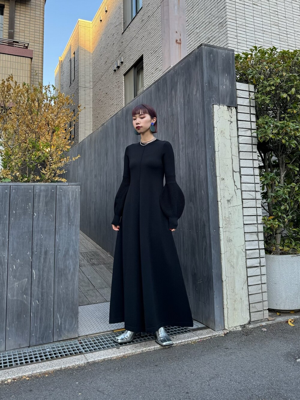 ブラック系のワンピース、シルバー系のブーツ、シルバー系のネックレスを着用したレディースの春コーディネートの1枚目の写真