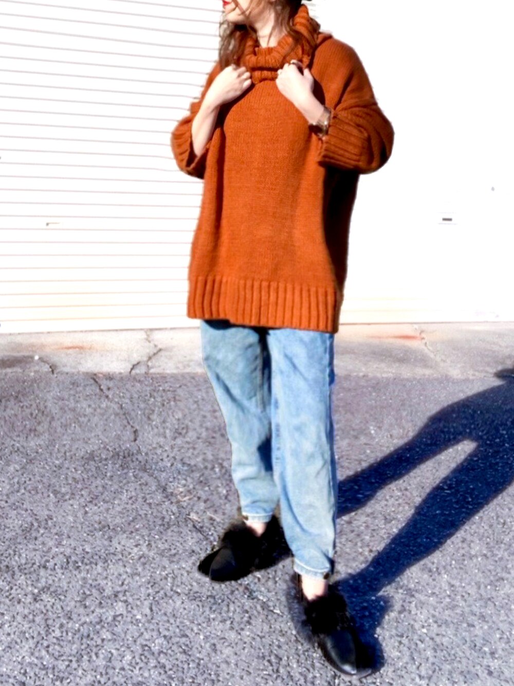 オレンジ系のニット/セーター、ブルー系のデニムパンツ、ブラック系のシューズを着用したレディースの冬コーディネートの1枚目の写真