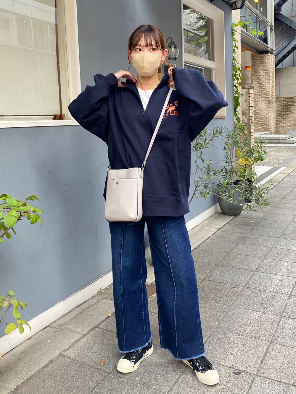 ブルー系のスウェット、ブルー系のデニムパンツ、ブラック系のスニーカーを着用したレディースの秋コーディネートの1枚目の写真